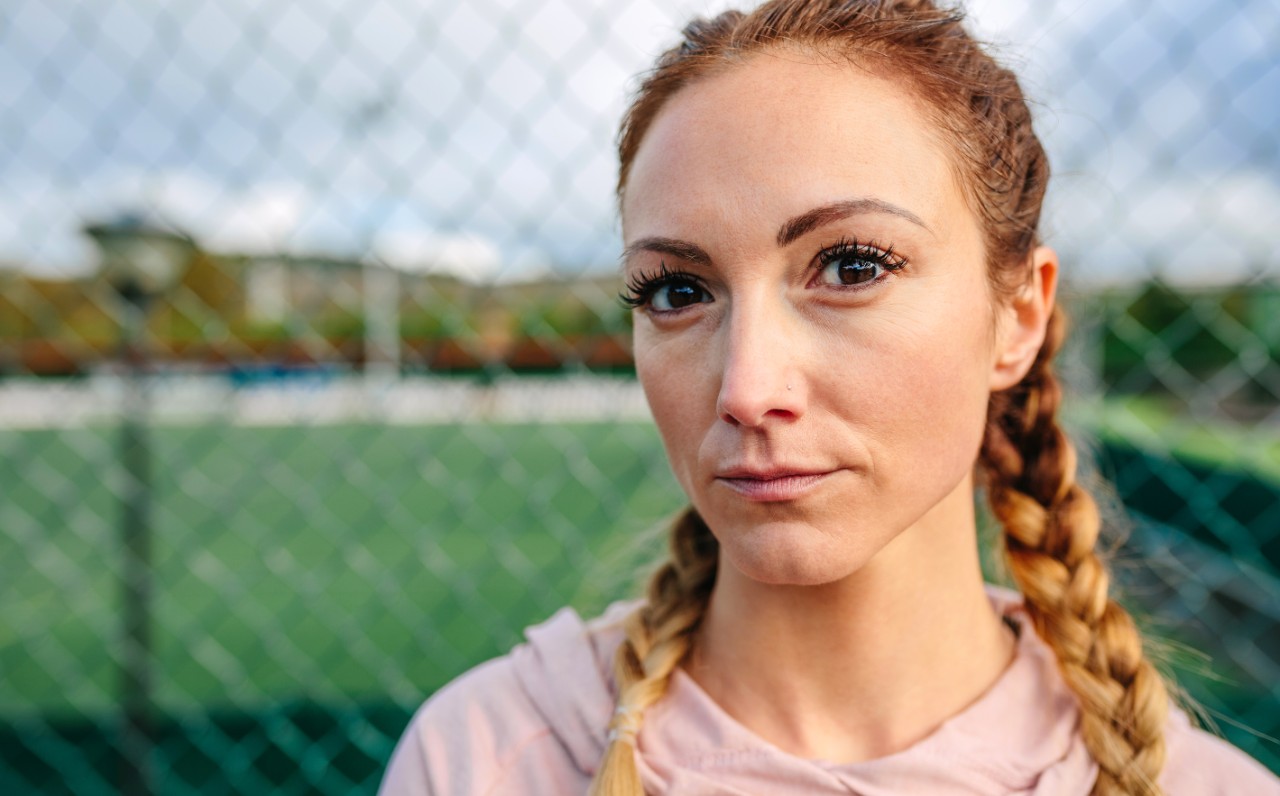 Portrait of serious young sportswoman with boxer braids looking camera